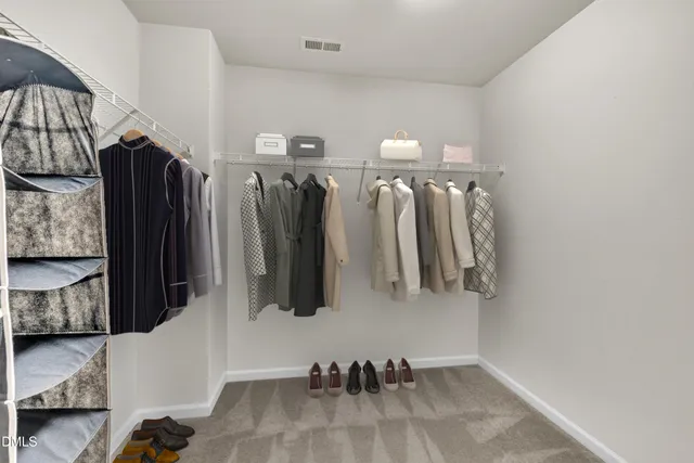 a view of walk in closet with clothes and shoes