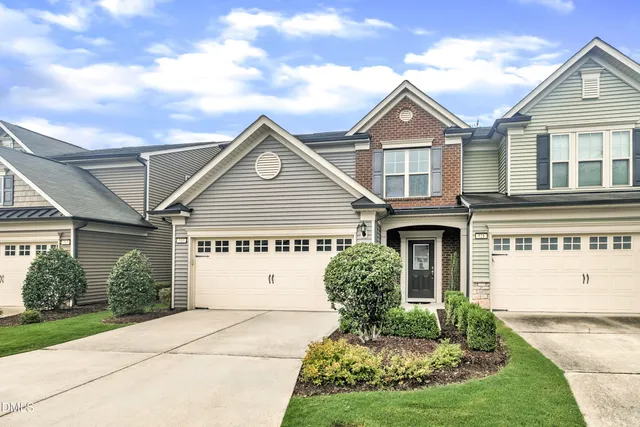 a view of house with garden and tall tress