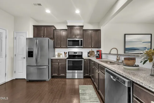 a kitchen with granite countertop a refrigerator and a sink