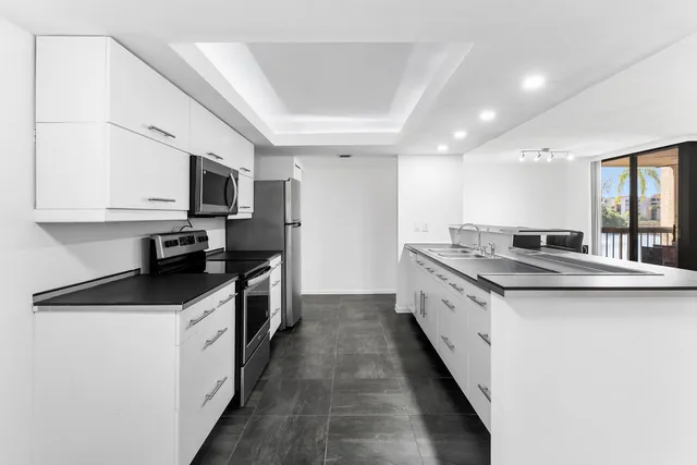 a kitchen with granite countertop a sink and steel appliances