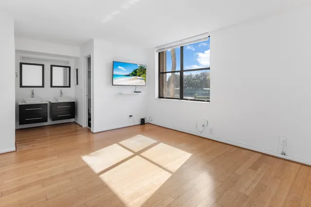 an empty room with windows and cabinet