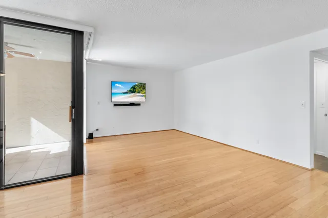 a view of empty room with wooden floor