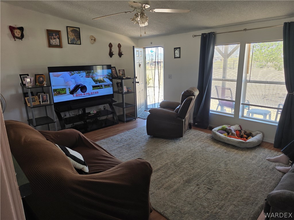 4182 Canelo Road Golden Valley, AZ 86413 - Photo 20 of 31 This living space features wood flooring, a ceiling fan, and large windows that provide natural illumination