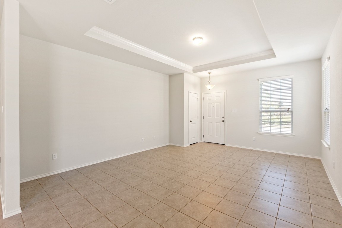 500 Martha Drive Buda, TX 78610 - Photo 3 of 7 Unfurnished room featuring a tray ceiling and light tile patterned flooring