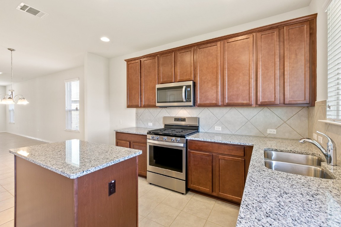 500 Martha Drive Buda, TX 78610 - Photo 4 of 7 Kitchen with brown cabinets, appliances with stainless steel finishes, healthy amount of natural light, and recessed lighting