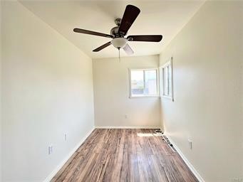 15962 M Street, Unit A Mojave, CA 93501 - Photo 11 of 21 an empty room with wooden floor ceiling fan and windows