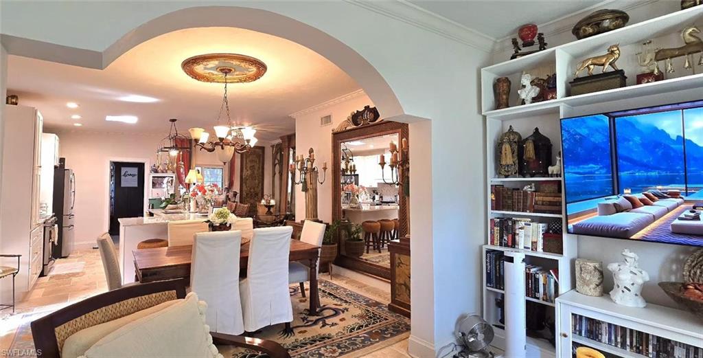 Undisclosed Address Naples, FL 34104 - Photo 17 of 40 Dining space with arched walkways, a chandelier, ornamental molding, and baseboards