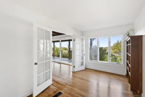 an empty room with windows and mirror