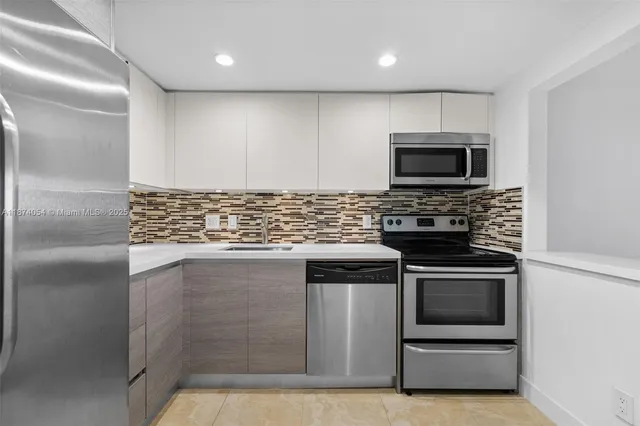 a kitchen with kitchen island stainless steel appliances and cabinets