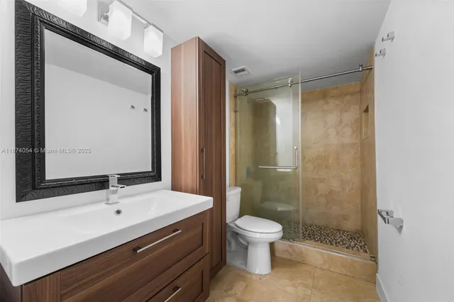 a bathroom with a sink a toilet and shower