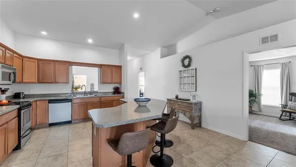 a kitchen with stainless steel appliances granite countertop sink stove and refrigerator