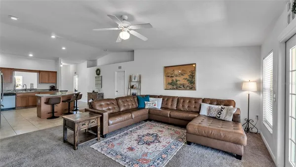 a living room with furniture and a view of kitchen