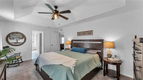 a bedroom with a bed a chandelier and a table