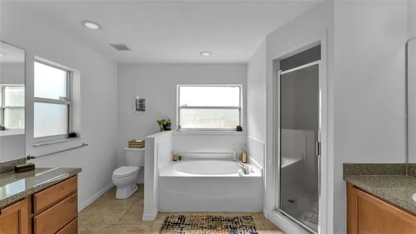 a bathroom with a granite countertop toilet a sink and a bathtub