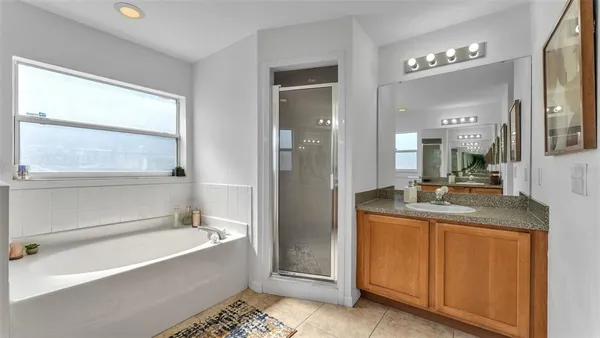 a bathroom with a granite countertop sink a mirror and a bathtub