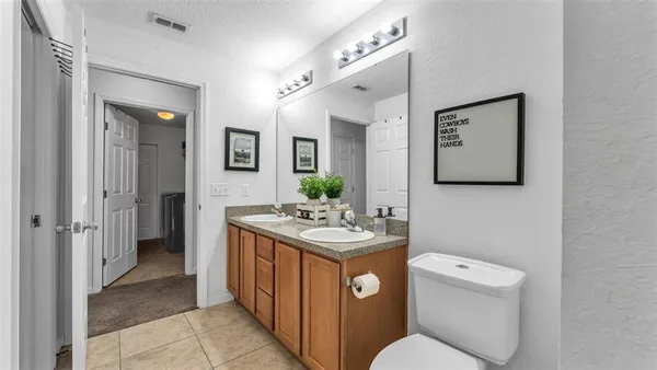 a spacious bathroom with a toilet sink and mirror
