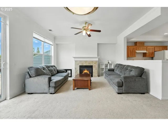a living room with furniture a fireplace and a ceiling fan