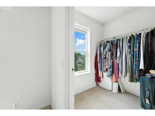 a view of walk in closet with clothes