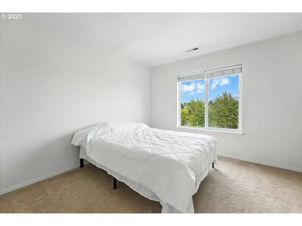 a bed sitting in a bedroom next to a window