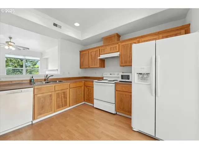 a kitchen with white cabinets and white appliances