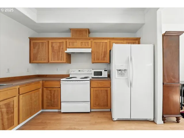 a kitchen with stainless steel appliances a stove a refrigerator and cabinets
