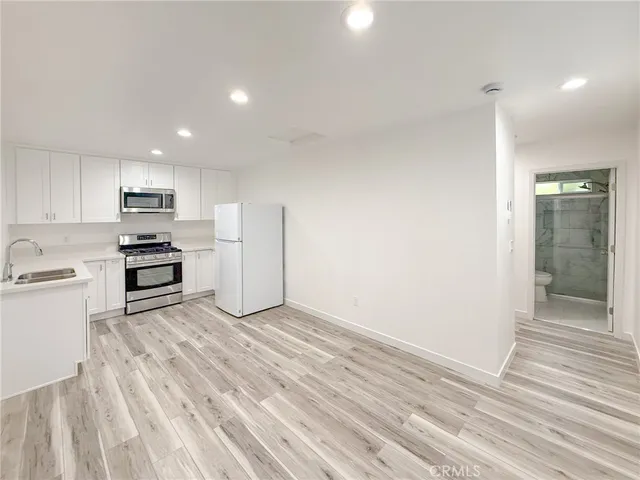 a kitchen with white cabinets and stainless steel appliances