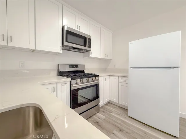 a kitchen with stainless steel appliances granite countertop a refrigerator a stove top oven a sink and dishwasher