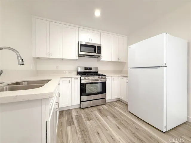 a kitchen with white cabinets and white appliances