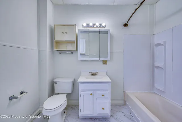 a bathroom with a sink toilet vanity and bathtub