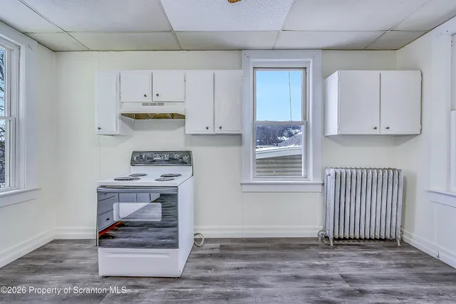 a view of kitchen with wooden floor and cabinets