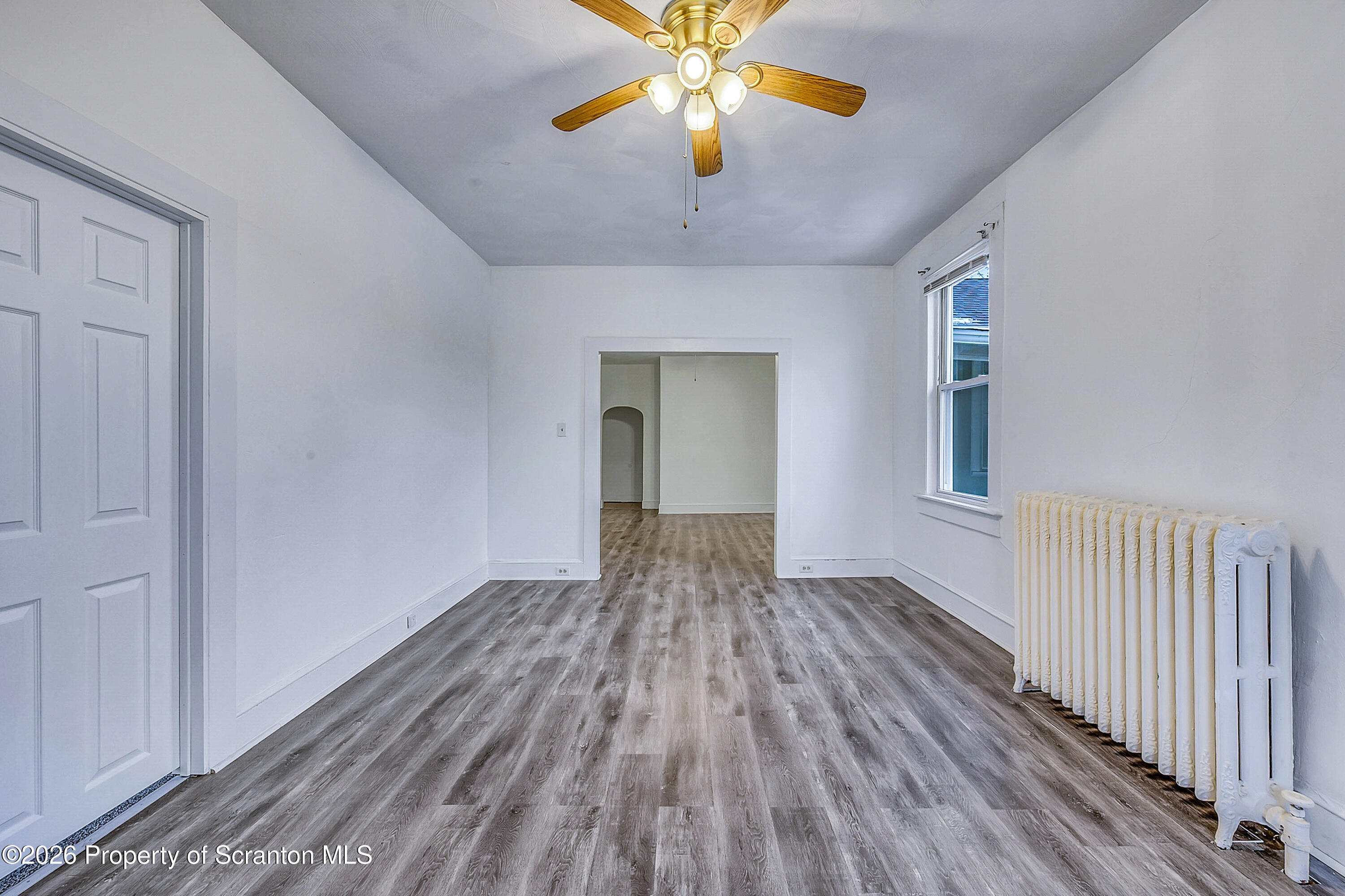 228 North Main Street Taylor, PA 18517 - Photo 9 of 19 a view of an empty room with window and wooden floor