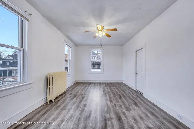 wooden floor in an empty room with a window
