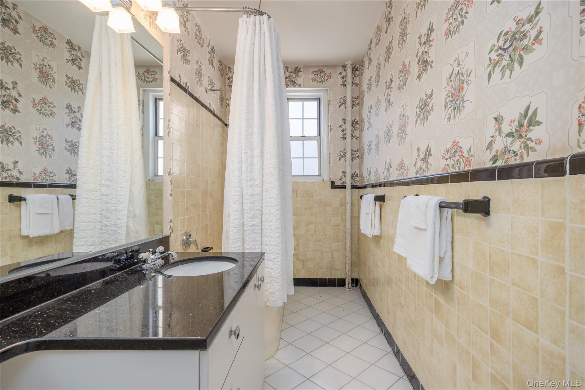 25 Parkview Avenue, Unit 2K Bronxville, NY 10708 - Photo 23 of 26 a bathroom with a granite countertop sink a mirror and a shower