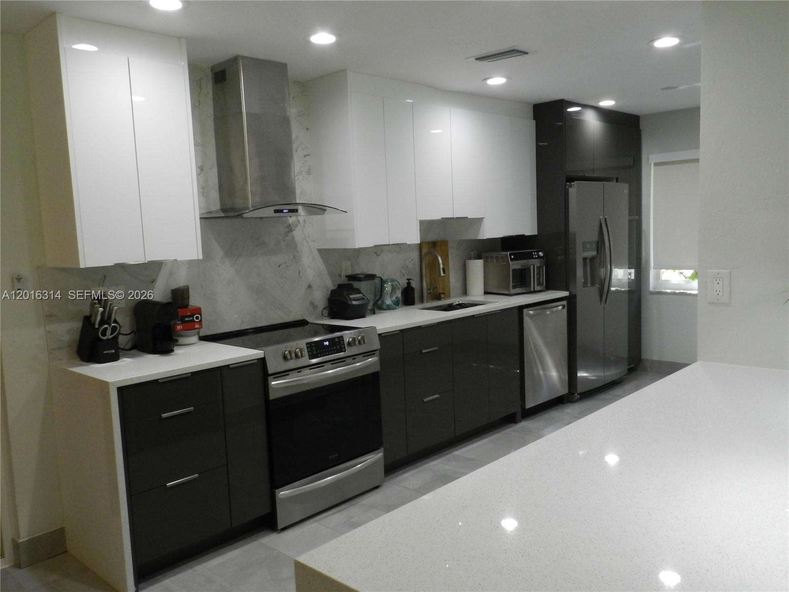 305 Northwest 42nd Street Boca Raton, FL 33431 - Photo 10 of 31 a kitchen with stainless steel appliances granite countertop a sink a stove and refrigerator