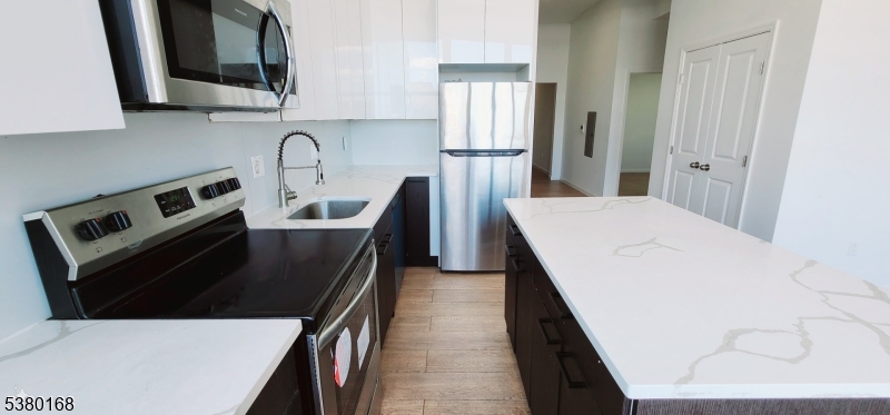 30 Howe Avenue, Unit 304 Passaic, NJ 07055 - Photo 11 of 12 a kitchen with a sink a stove and refrigerator