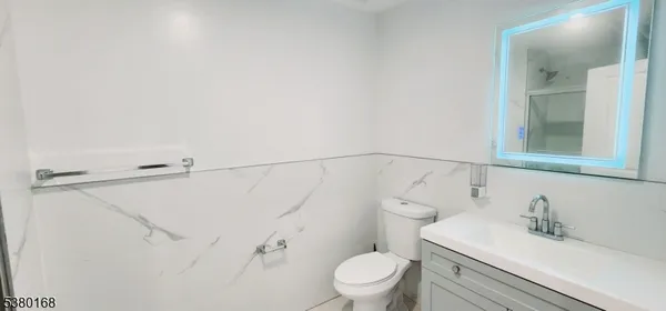 a bathroom with a sink vanity mirror and toilet