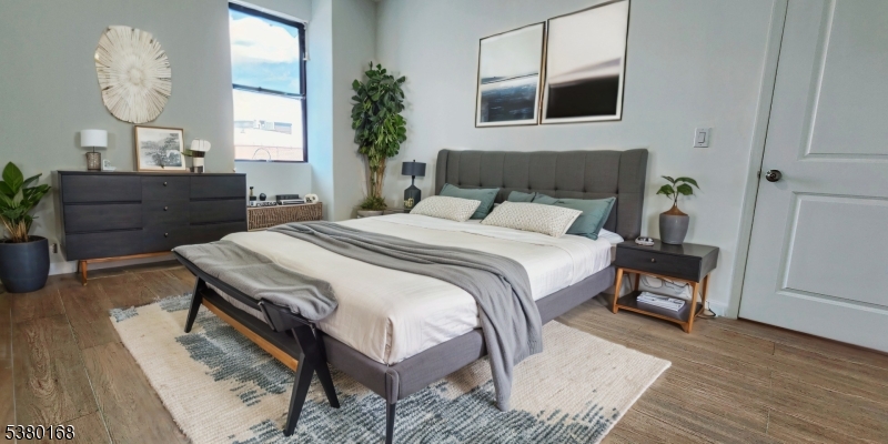 30 Howe Avenue, Unit 304 Passaic, NJ 07055 - Photo 7 of 12 a bedroom with a bed and wooden floor