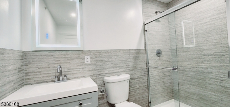 30 Howe Avenue, Unit 304 Passaic, NJ 07055 - Photo 8 of 12 a bathroom with a sink a toilet and shower