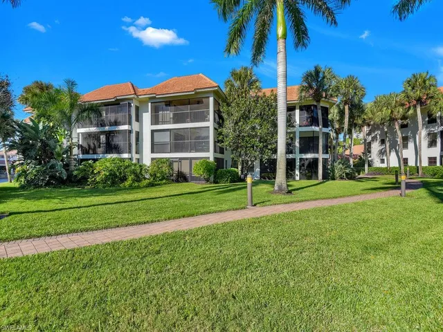 a view of a house with a yard and palm trees