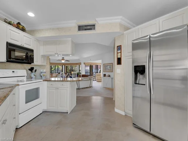 a kitchen with white cabinets and white appliances