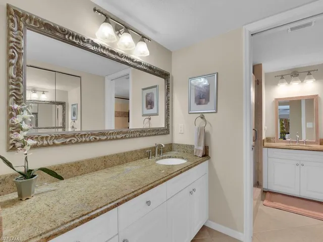 a bathroom with a granite countertop sink mirror and bathtub
