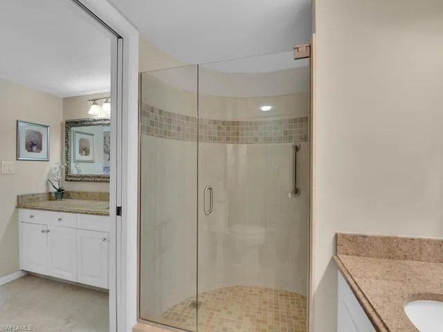 a bathroom with a granite countertop sink a mirror and a shower