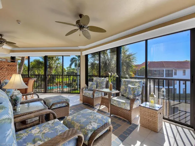 a living room with furniture large windows and wooden floor