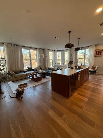 a large kitchen with a large counter top furniture a sink and a chandelier