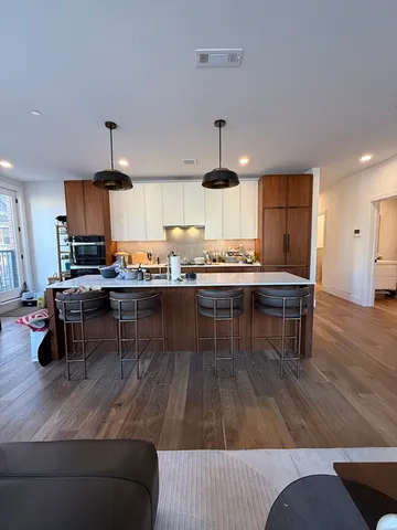 a living room with stainless steel appliances kitchen island granite countertop furniture and wooden floors