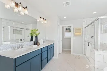 a bathroom with a double vanity sink mirror and shower
