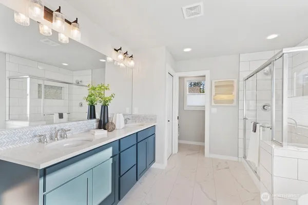 a bathroom with a shower a sink and a mirror