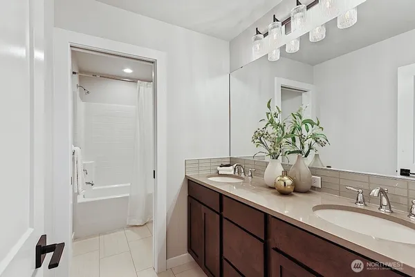 a bathroom with a granite countertop sink a mirror and a bathtub