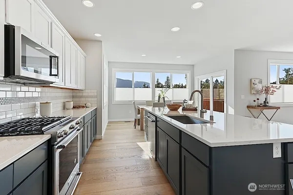 a kitchen with stainless steel appliances a sink stove top oven and cabinets