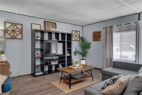 a living room with furniture a window and a flat screen tv